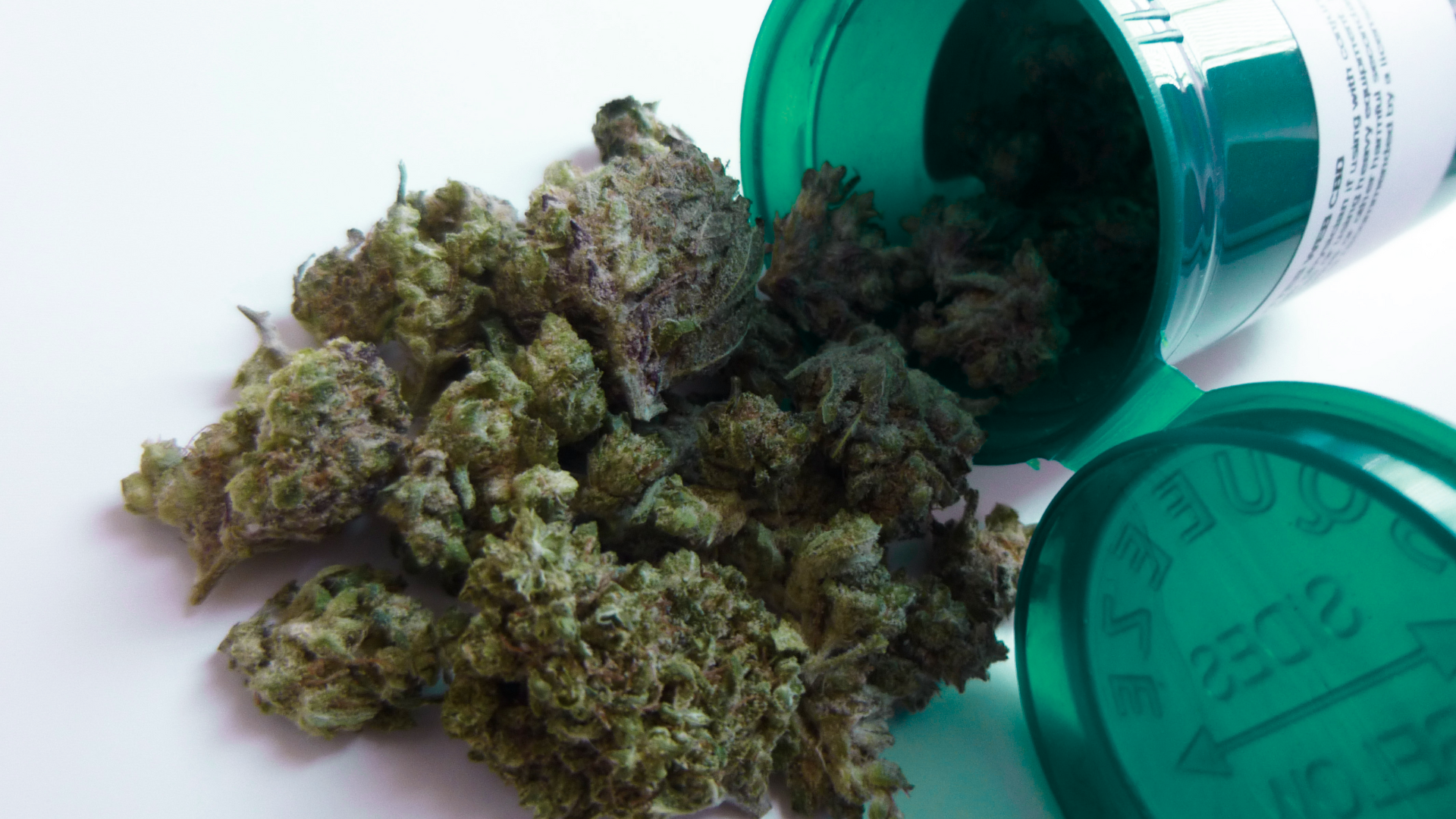 Green medical cannabis container with an eighth in it.