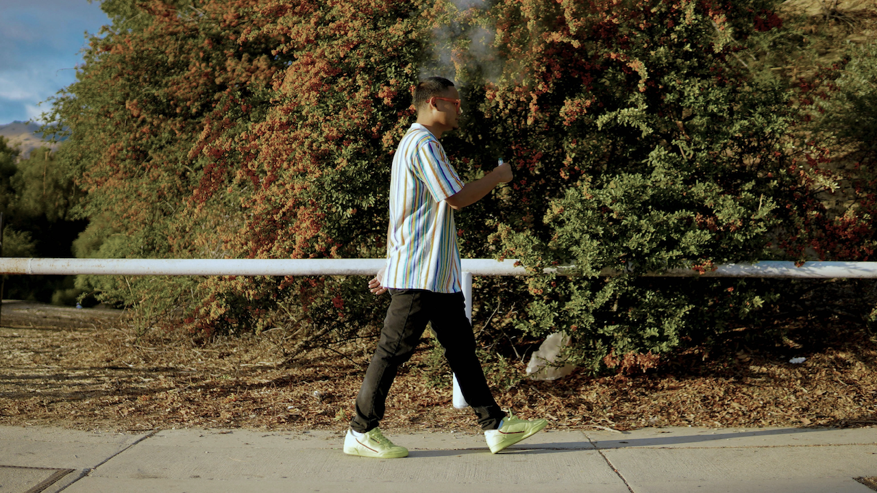 Man walking outside in NJ while smoking a joint.