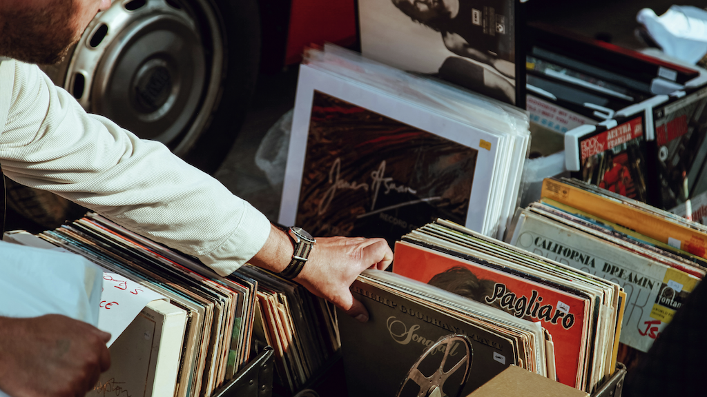 Man shuffling though a box of vintage records.