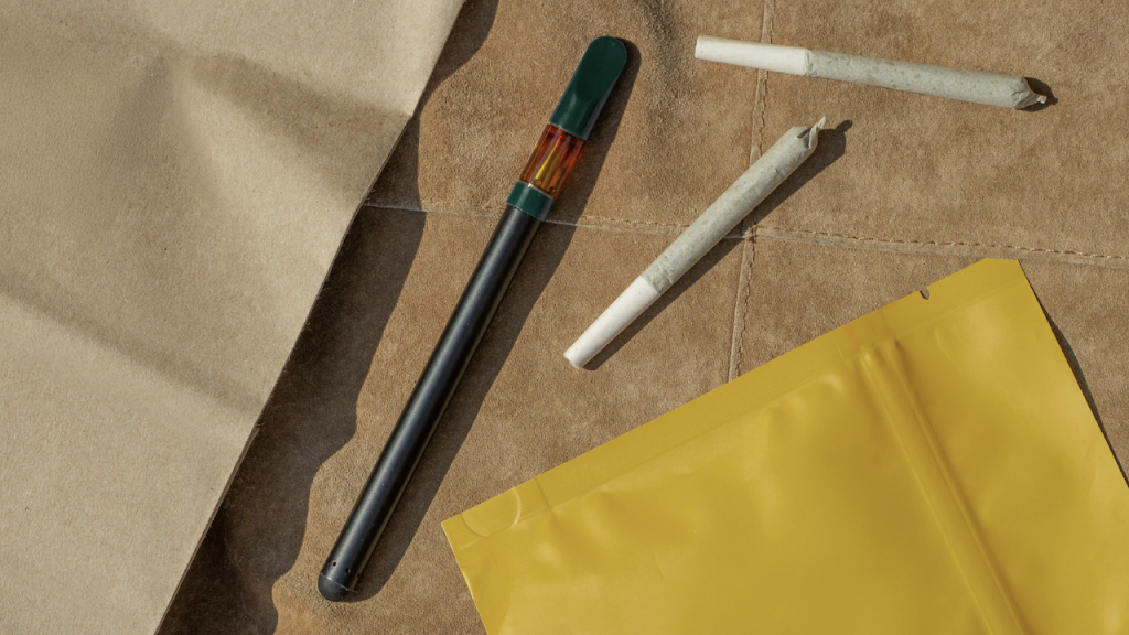 A THC vape and a joint on a leather background.